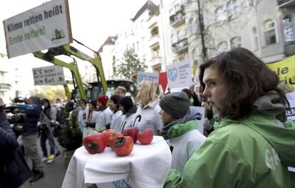 Una joven muestra manzanas dañadas durante una protesta de Greenpeace a las puertas del tribunal administrativo de Berlín el jueves.