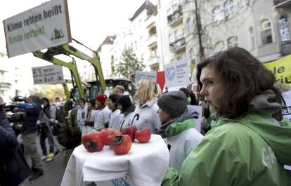 Una joven muestra manzanas dañadas durante una protesta de Greenpeace a las puertas del tribunal administrativo de Berlín el jueves. 