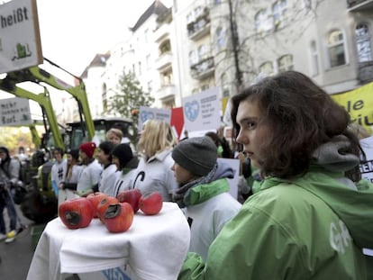 Una joven muestra manzanas dañadas durante una protesta de Greenpeace a las puertas del tribunal administrativo de Berlín el jueves. 