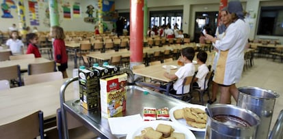Dos trabajadoras y varios alumnos en un comedor escolar.
