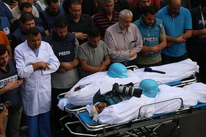 Friends and family mourn the bodies of Palestinian journalists Muhammad Sobh and Saeed Al-Taweel, who were killed during their work by Israeli airstrikes, on October 10, 2023, in Gaza City.