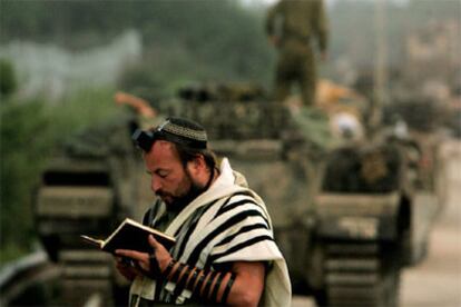 Un soldado israelí reza delante de los tanques en una carretera del sur de Líbano.