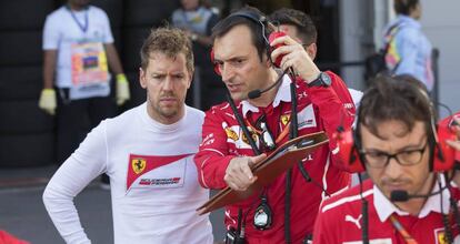 Sebastian Vettel escucha a un miembro del equipo Ferrari en el circuito de Bakú.