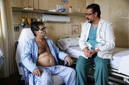 El paciente Fernando Abuín, recién trasplantado, conversa con uno de los doctores que lo atienden en el hospital Gregorio Marañón.