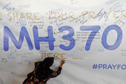 Los familiares de los viajeros chinos del vuelo MH370 de Malaysia Airlines reclamaron que se intensifique la búsqueda del avión desaparecido no sólo por mar, sino también por tierra, después de que algunos de ellos llamaran a teléfonos de sus allegados y "dieran tono". En la imagen, una mujer escribe un mensaje para los pasajeros del avión desaparecido.