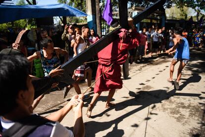 En varias ciudades de la provincia de Pampanga, al norte de Manila, las calles albergaron procesiones en las que hombres de todas las edades se azotaron con látigos las espaldas desnudas mientras ofrecían a los adultos y niños del público que les flagelaran también. En la imagen, un penitente transporta una cruz, en San Fernando (Filipinas).