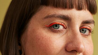 Una chica con eyeliner naranja.