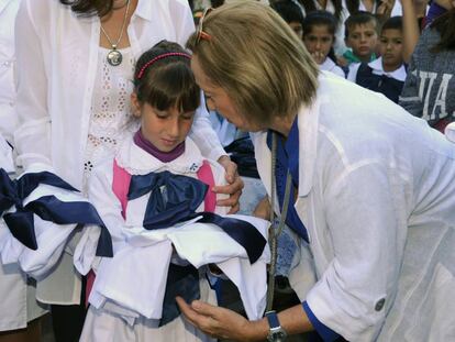 La ministra de Educaci&oacute;n de Uruguay entrega materiales escolares a una ni&ntilde;a durante la celebraci&oacute;n del inicio del a&ntilde;o escolar, en Montevideo.