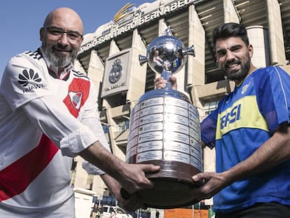 Fabio Vides e Leonardo Polzello, torcedores do River e Boca, posam com uma réplica da Taça Libertadores no Santiago Bernabéu.