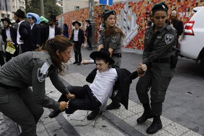 Las fuerzas de seguridad israelíes se llevan en volandas a un joven manifestante durante una manifestación de judíos ultraortodoxos en Jerusalén.