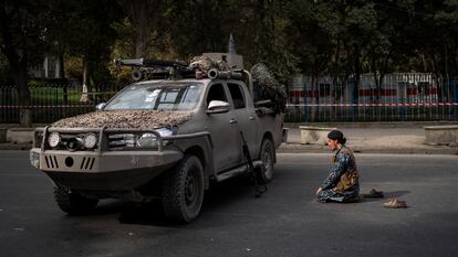 Um combatente talibã reza diante de um veículo militar, na sexta-feira em Cabul.