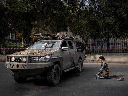 Um combatente talibã reza diante de um veículo militar, na sexta-feira em Cabul.