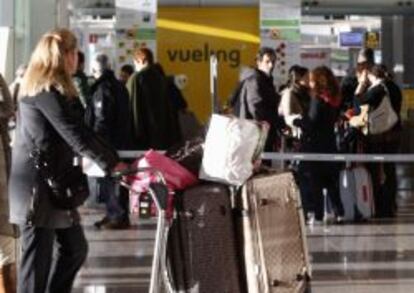 Varios pasajeros, en la cola de check-in en el aeropuerto de Barcelona.