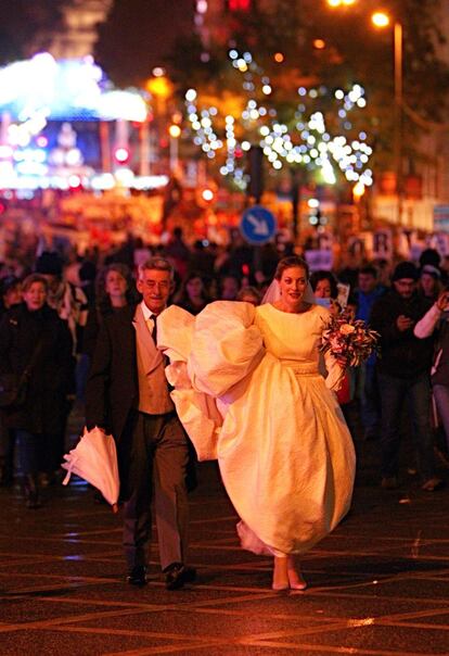 Una novia acompañada de su padrino en medio de la manifestación en la que han terminado las Marchas de la Dignidad de Madrid. Frente a la iglesia de las Calatravas, en plena calle Alcalá, esperaban los invitados a la boda.