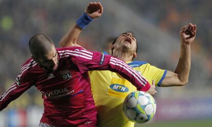 Savvas Poursaitidesm, del Apoel, pelea el cuero con el jugador del Lyon Lisandro.