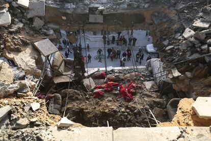 Un grupo de personas, junto a un edificio destrozado por los ataques israelíes este miércoles en Rafah. 