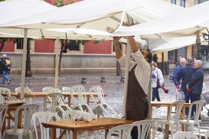 Un camarero coloca los calefactores en una terraza, este viernes en Sevilla.