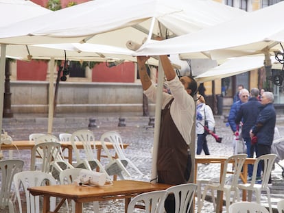 Un camarero coloca los calefactores en una terraza, este viernes en Sevilla.