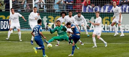 El centrocampista del Getafe, Pablo Sarabia (d), chuta en un libre indirecto ante el portero costarricense del Real Madrid, Keylor Navas (c).