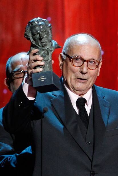 El director Mario Camus sostiene el Goya honorario a toda su carrera.