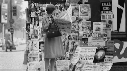 Liz Karlson, editora de ropa deportiva de la revista Glamour, leyendo el periódico en un quiosco de París.
