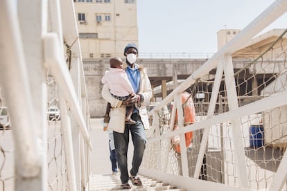 Ousmane con su hija en brazos, sube al barco médico 'Global Mercy', en Dakar, para que la niña sea operada de labio leporino.