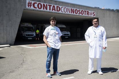 Pablo Herrero (izquierda) y Luis Antuña, encargados de distintas áreas de Urgencias, frente a la zona de ambulancias del HUCA y un rótulo que los propios sanitarios decidieron instalar para animar a sus compañeros. Los servicios de Urgencias y Atención Primaria rural se han coordinado con la premisa de evitar que los hospitales se saturaran y se convirtieran en focos de contagio.