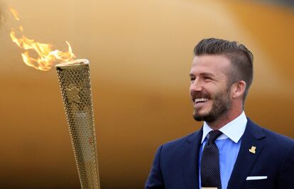 Beckham sostiene la antorcha olímpica al trasladarla desde Atenas hasta el Reino Unido el pasado mayo.