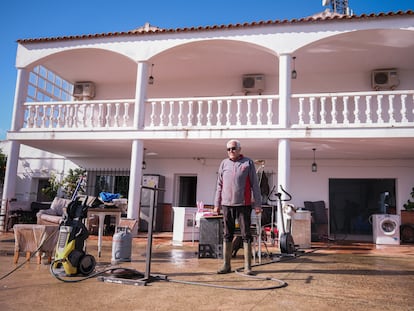 José Luis Fernández, vecino del anejo de Gévora (Badajoz), posa en la fachada de su casa junto a algunos de los muebles y electrodomésticos que ha podido rescatar tras las inundaciones.