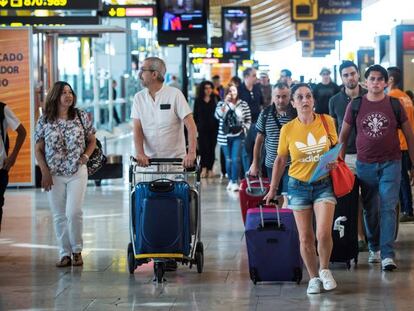 Viajeros transitan por la terminal 4 del aeropuerto de Barajas en Madrid. 