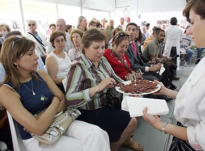 Una asistente a uno de los talleres de cocina degusta un embutido.