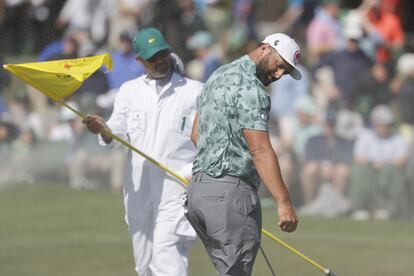 Jon Rahm y su caddie, protegiéndose del viento.