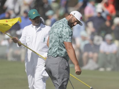 Jon Rahm y su caddie, protegiéndose del viento.