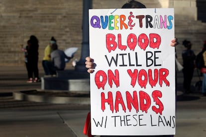 A protester outside the Kansas Statehouse holds a sign after a rally for transgender rights on the Transgender Day of Visibility, Friday, March 31, 2023