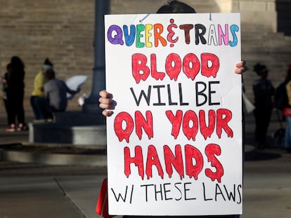 A protester outside the Kansas Statehouse holds a sign after a rally for transgender rights on the Transgender Day of Visibility, Friday, March 31, 2023