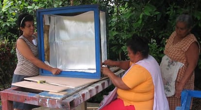 Unas mujeres construyen una cocina solar. 