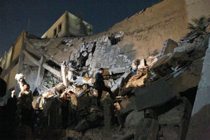 Soldados libios comprueban el estado del edificio administrativo en el complejo residencial de Gadafi destruido esta madrugada por el impacto de un misil.