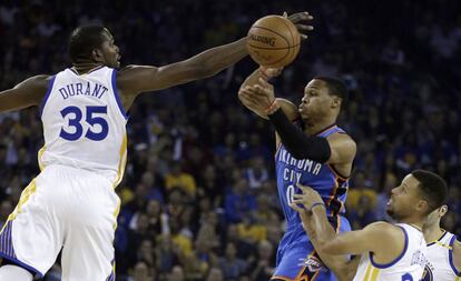 Durant intenta taponar a Westbrook, junto a Curry.