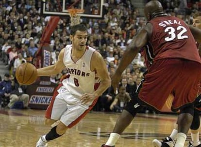 El jugador de los Toronto Raptors, el espa?ol Jos Manuel Caldern, intenta superar la defensa del pivot Shaquille O'Neal de los Heat de Miami.