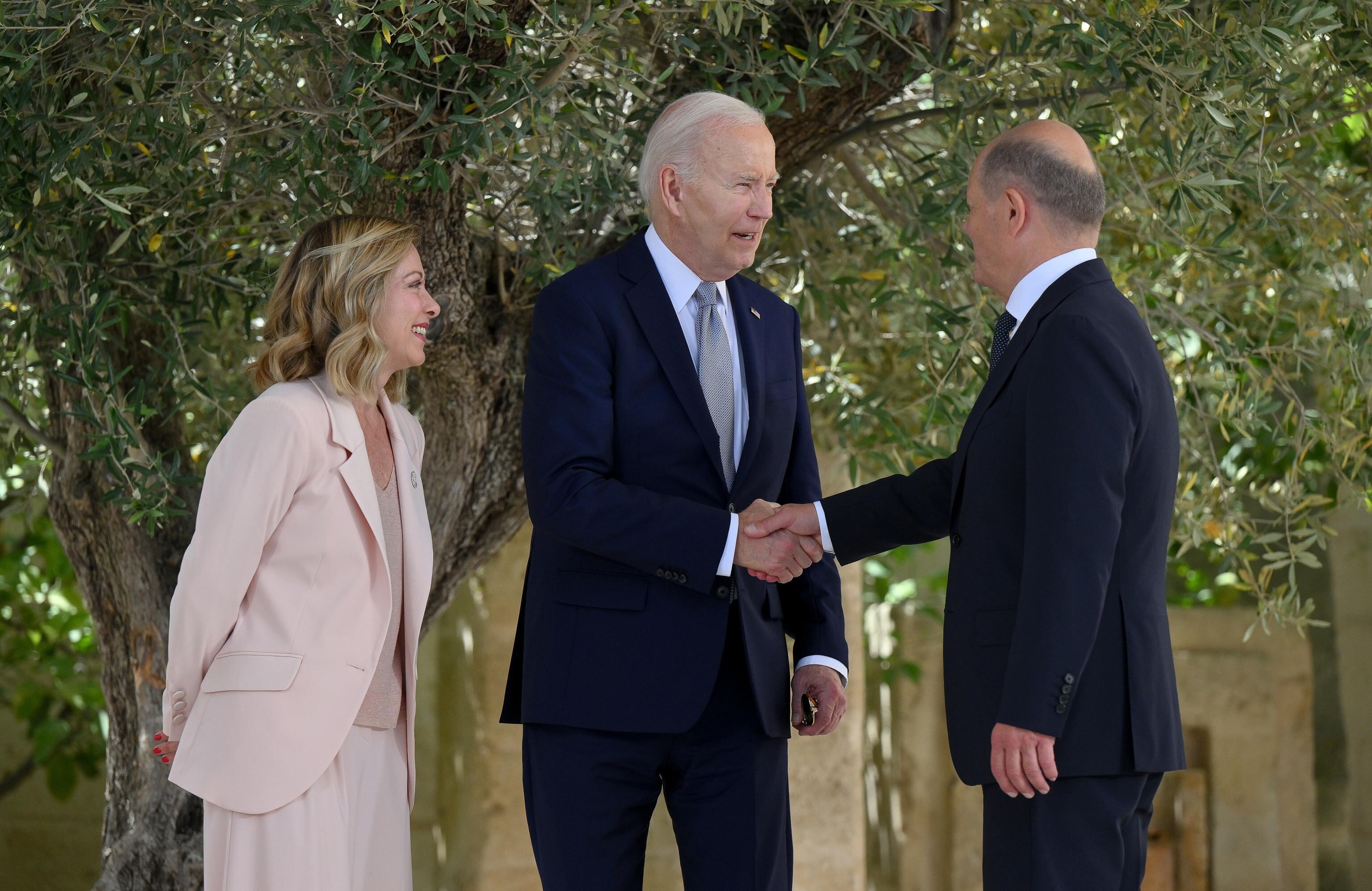 Meloni observa al presidente de los Estados Unidos, Joe Biden, saludar al canciller alemán, Olaf Scholz, durante la cumbre del G-7.