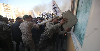 Un grupo de manifestantes intenta romper un cristal blindado de la embajada estadounidense en Bagdad (Irak), el 31 de diciembre.