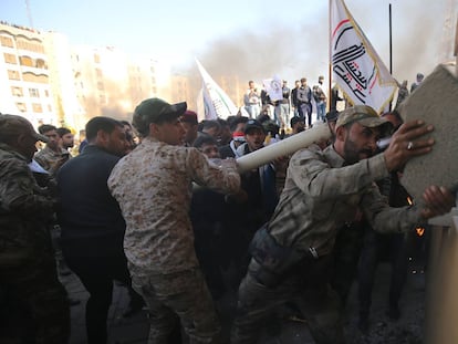 Un grupo de manifestantes intenta romper un cristal blindado de la embajada estadounidense en Bagdad (Irak), el 31 de diciembre.