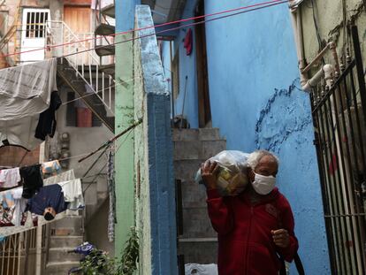 Un hombre carga una bolsa de comida repartida por una ONG en una favela de Río de Janeiro, el pasado mes de junio.