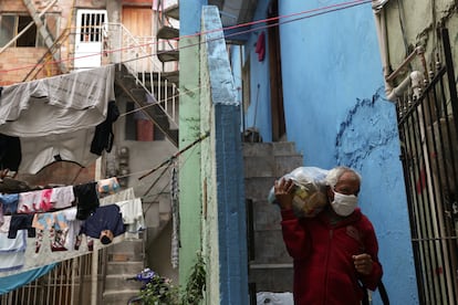 Un hombre carga una bolsa de comida repartida por una ONG en una favela de Río de Janeiro, el pasado mes de junio.