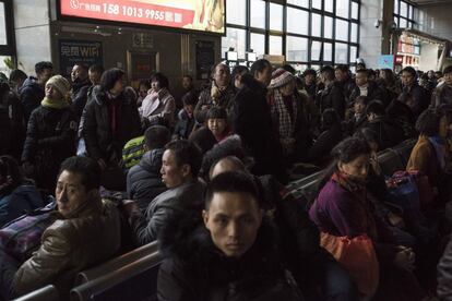 Viajeros esperan la salida de su tren en la Estación de Pekín Oeste.