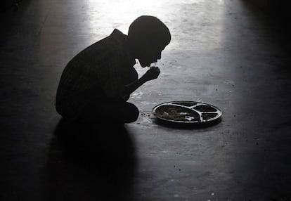Un niño come en el suelo de un orfanato en la ciudad india de Chennai.
