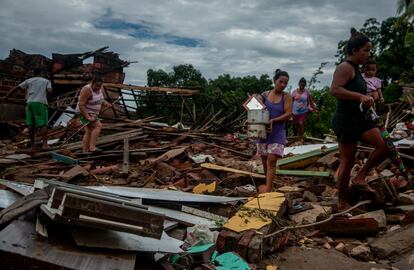 Personas tratan de rescatar sus pertenencias de casas destruidas por inundaciones provocadas por lluvias, en la ciudad de Itamb, en el Estado de Baha.