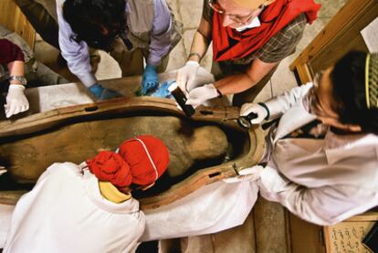 Recogida de muestras en el interior de la Dama Blanca, apodo de un ataúd hallado en 2003 en la tumba de Djehuty, y (arriba) Ushebty de madera.