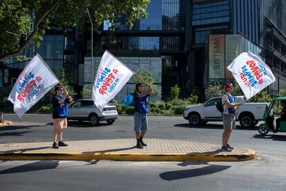 Personas ondean banderas de la campaña a Favor, este jueves en Santiago.