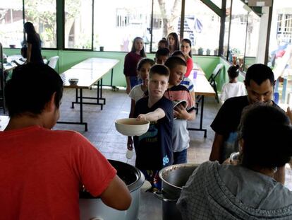 Reparto de comida a un grupo de niños acogidos en una casa de un vecino de San José, en Costa Rica.